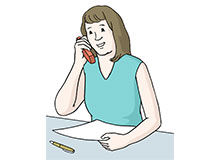 Eine Frau berät am Telefon. Sie macht sich dabei Notizen.